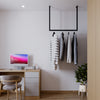 Deckenmontierte Kleiderstange aus schwarzen pulverlackierten Eisenrohren als minimalistische Garderobe im Büro