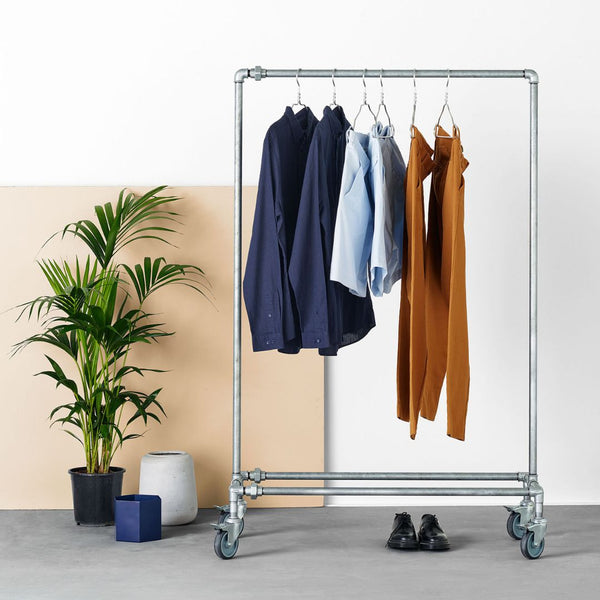 frei stehender Kleiderständer auf Rollen in silbernen Eisenrohren für industrielles Design